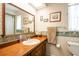 Bathroom featuring a wood vanity, large mirror, and floral wallpaper at 1830 Oak Forest S Dr, Clearwater, FL 33759