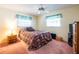 Bedroom with a ceiling fan, two windows, and carpet flooring at 1830 Oak Forest S Dr, Clearwater, FL 33759