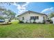 Single story home featuring a well-maintained lawn, tidy garden beds, and neutral color scheme at 1830 Oak Forest S Dr, Clearwater, FL 33759