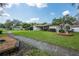 Inviting home with a well-manicured lawn, mature trees, and a paved walkway at 1830 Oak Forest S Dr, Clearwater, FL 33759
