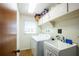 Laundry room with white washer and dryer, utility sink, and window at 1830 Oak Forest S Dr, Clearwater, FL 33759