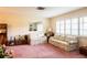 Bright living room featuring plantation shutters, neutral walls, and plush pink carpet at 1830 Oak Forest S Dr, Clearwater, FL 33759