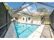 Screened-in pool with patio and a view of the home's back exterior at 1830 Oak Forest S Dr, Clearwater, FL 33759