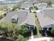 Aerial view showcases the home's location within a well-maintained community with neatly manicured lawns and mature trees at 203 Oceania Ct, Apollo Beach, FL 33572