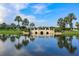 Picturesque bridge over a tranquil lake, surrounded by lush landscaping and palm trees at 203 Oceania Ct, Apollo Beach, FL 33572