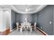 Dining room features hardwood floors, tray ceiling, modern decor, and a large rug at 203 Oceania Ct, Apollo Beach, FL 33572