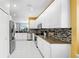 Bright kitchen features white cabinetry, mosaic backsplash, stainless appliances, and granite countertops at 203 Oceania Ct, Apollo Beach, FL 33572