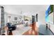 Bright open-concept living room with hardwood floors, modern furnishings, and seamless flow to the adjacent kitchen at 203 Oceania Ct, Apollo Beach, FL 33572