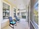 Inviting screened porch furnished with rocking chairs offering a cozy spot to enjoy the peaceful neighborhood scenery at 203 Oceania Ct, Apollo Beach, FL 33572