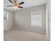 An ample bedroom featuring neutral carpeting, a ceiling fan, and a window for natural light at 2442 Silvermoss Dr, Wesley Chapel, FL 33544