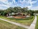Well-maintained community entrance with a brick sign, fountains, landscaping, and sidewalk at 2442 Silvermoss Dr, Wesley Chapel, FL 33544