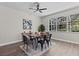 Bright dining room with wood table, black chairs, and large windows overlooking greenery at 2442 Silvermoss Dr, Wesley Chapel, FL 33544