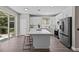 Modern kitchen with white cabinets, stainless steel appliances, and expansive island at 2442 Silvermoss Dr, Wesley Chapel, FL 33544