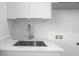 Laundry room with stainless steel sink, modern faucet, quartz countertops and white cabinetry at 2519 N Riverside Dr, Tampa, FL 33602