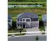 Aerial view of two-story home with lush landscaping and a three car garage at 2595 Wise River Ln, Zephyrhills, FL 33541