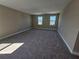 Spacious bonus room with plush carpeting and bright windows, perfect for relaxation or recreation at 2595 Wise River Ln, Zephyrhills, FL 33541