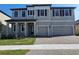 Charming two-story home featuring a two-car garage, manicured lawn, and classic architectural details at 2595 Wise River Ln, Zephyrhills, FL 33541