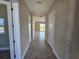 Inviting hallway with neutral walls, tiled floor, and doorways leading to various rooms at 2595 Wise River Ln, Zephyrhills, FL 33541