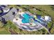 Community pool aerial view featuring a slide, lounge chairs, and a covered pavilion at 30226 Merilee Pl, Wesley Chapel, FL 33545