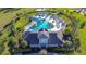 Aerial view of community pool and clubhouse surrounded by lush greenery and palm trees at 30226 Merilee Pl, Wesley Chapel, FL 33545