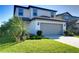 A well-manicured lawn and neatly trimmed bushes highlight this two-story home's exterior at 30226 Merilee Pl, Wesley Chapel, FL 33545