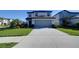 Charming two-story home boasts a well-manicured lawn and a long, paved driveway leading to the garage at 30226 Merilee Pl, Wesley Chapel, FL 33545