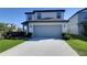 Two-story home showcasing a two-car garage, neutral siding, and a well-maintained front yard at 30226 Merilee Pl, Wesley Chapel, FL 33545