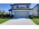 Two-story home featuring a spacious two car garage, concrete driveway, and manicured landscaping at 30226 Merilee Pl, Wesley Chapel, FL 33545