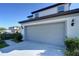 Two-story home featuring a spacious two car garage, concrete driveway, and manicured landscaping at 30226 Merilee Pl, Wesley Chapel, FL 33545