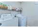 Functional laundry room with washer, dryer and shelf for supplies at 30226 Merilee Pl, Wesley Chapel, FL 33545