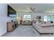 Inviting living room with modern decor, a ceiling fan, and ample natural light from the large window at 30226 Merilee Pl, Wesley Chapel, FL 33545