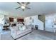 Open-concept living area flows into kitchen, featuring a ceiling fan and comfortable seating at 30226 Merilee Pl, Wesley Chapel, FL 33545