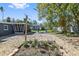 Landscaped backyard featuring a pea gravel lounge area, outdoor shower, garden and screened in lanai at 311 W Fern St, Tampa, FL 33604