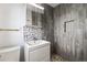 A bathroom with a vanity sink and modern shower with mosaic tile and wood look paneling at 311 W Fern St, Tampa, FL 33604