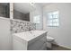 Bathroom featuring a bright white vanity and a designer backsplash plus a window for natural light at 311 W Fern St, Tampa, FL 33604