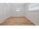 Bright bedroom featuring hardwood floors, white walls, window with blinds, and a closet with folding doors at 311 W Fern St, Tampa, FL 33604