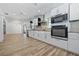 Bright, newly renovated kitchen with stainless steel appliances, white cabinets and wood floors at 311 W Fern St, Tampa, FL 33604