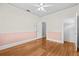 Bedroom featuring hardwood floors, white walls, pink trim, and a ceiling fan at 322 11Th N Ave, St Petersburg, FL 33701
