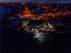 Night aerial view of waterfront home, showcasing boat dock, palm trees and tiki style covered patio at 351 S Julia Cir, St Pete Beach, FL 33706