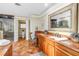Bathroom features a wood vanity with granite countertops, a large mirror, and a separate shower and toilet area at 351 S Julia Cir, St Pete Beach, FL 33706