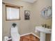 Quaint bathroom features a pedestal sink, a toilet, and a framed picture, offering a simple yet functional space at 351 S Julia Cir, St Pete Beach, FL 33706