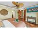 Comfortable bedroom features terracotta floors, ceiling fan, arched doorways, and a flat screen television at 351 S Julia Cir, St Pete Beach, FL 33706