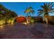 Well-lit driveway featuring brick pavers leading to the two-car garage, surrounded by lush tropical landscaping at 351 S Julia Cir, St Pete Beach, FL 33706