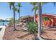 Charming exterior view of a waterfront property, showcasing lush landscaping and a relaxing tiki hut at 351 S Julia Cir, St Pete Beach, FL 33706