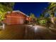 Night view of brick home with paver drive, lush landscaping and well-lit entrance at 351 S Julia Cir, St Pete Beach, FL 33706