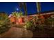 Night view of brick home with paver walkway, lush landscaping and well-lit entrance at 351 S Julia Cir, St Pete Beach, FL 33706