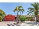 Charming one-story home with a red exterior, tile roof, and lush tropical landscaping at 351 S Julia Cir, St Pete Beach, FL 33706