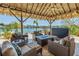 Inviting outdoor lounge with wicker furniture, a fire pit, and a TV, perfect for relaxing and entertaining by the water at 351 S Julia Cir, St Pete Beach, FL 33706