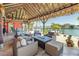 Relaxing waterfront patio with comfortable seating and a tiki-style roof, ideal for enjoying scenic views at 351 S Julia Cir, St Pete Beach, FL 33706