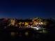 Nighttime view of waterfront home, showcasing boat dock, palm trees and tiki style covered patio at 351 S Julia Cir, St Pete Beach, FL 33706